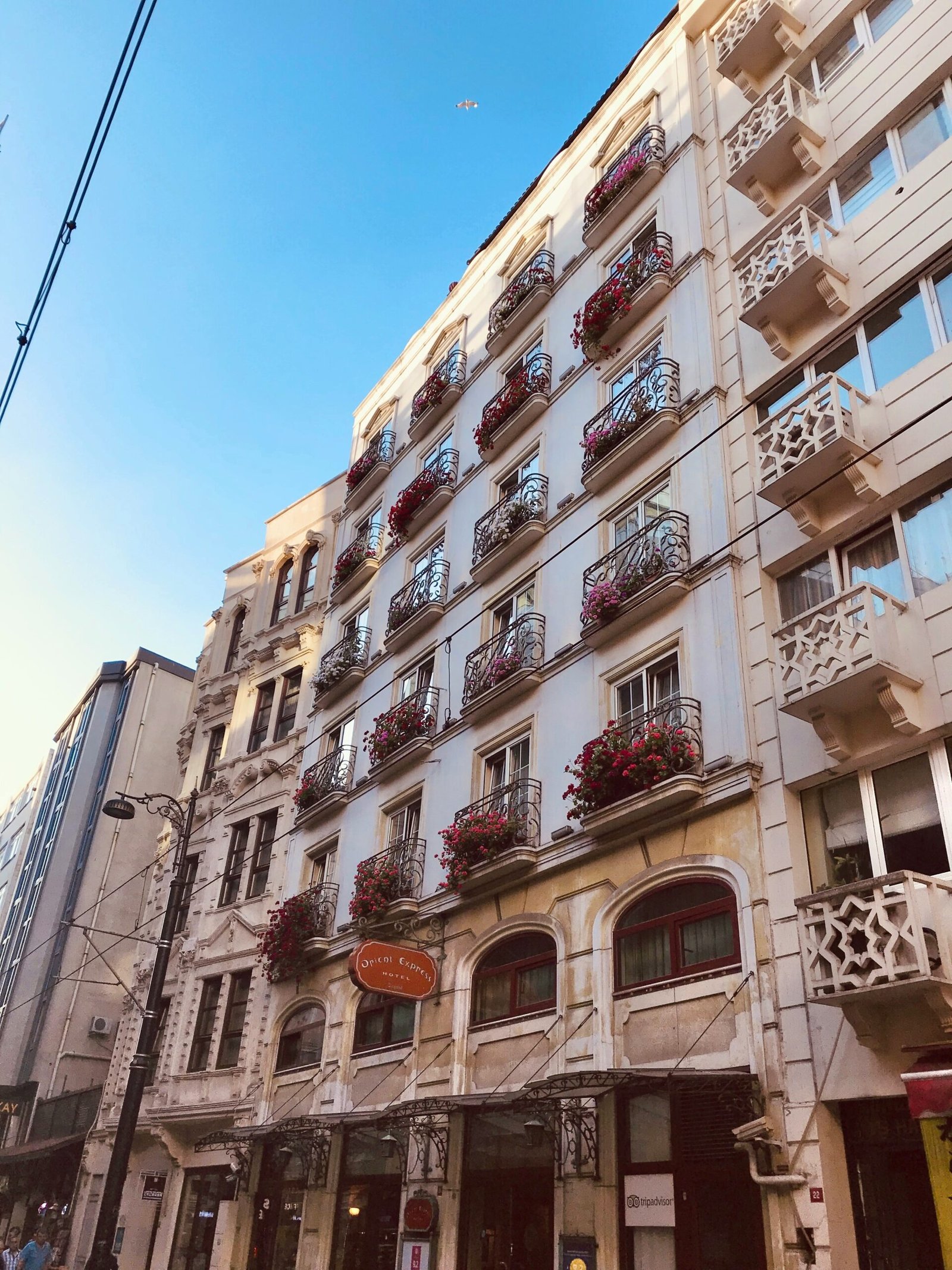 a tall building with balconies and flowers on the balconies